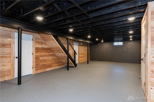 basement with stairway and wood walls