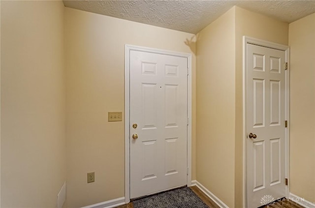 entryway with a textured ceiling and baseboards