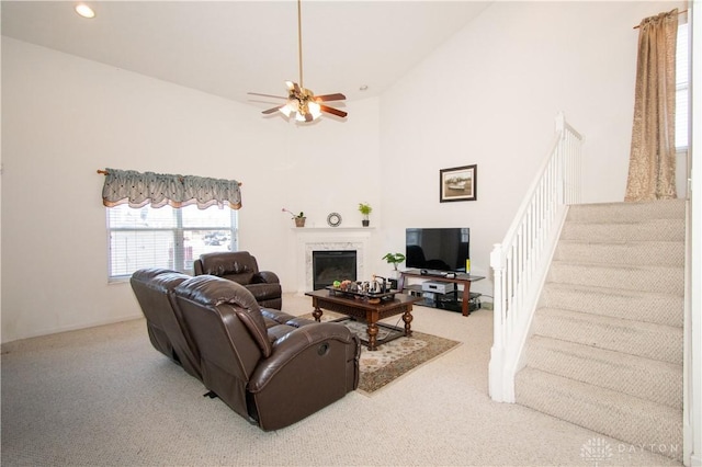 living room featuring stairs, a fireplace, a towering ceiling, and carpet