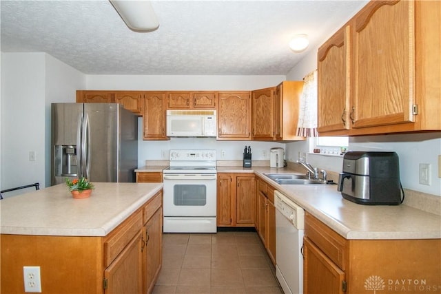 kitchen featuring light countertops, white appliances, light tile patterned flooring, and a sink