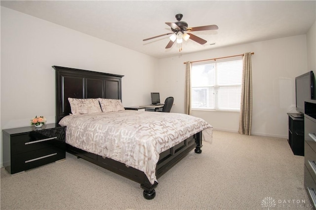 bedroom featuring light carpet, a ceiling fan, and baseboards