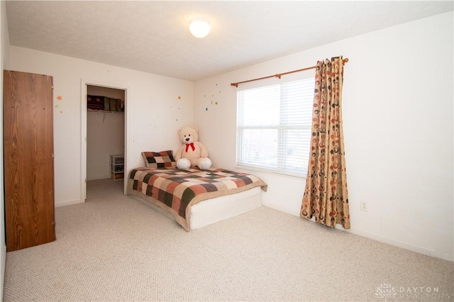 carpeted bedroom with a closet, a spacious closet, and a textured ceiling