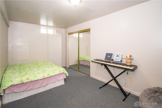 carpeted bedroom with a closet and baseboards