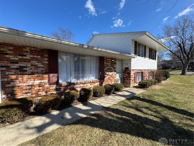 view of front of house with brick siding and a front lawn