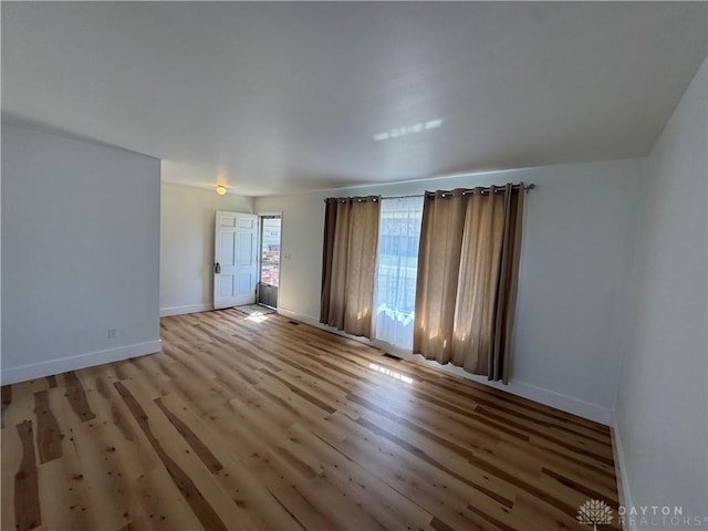 spare room featuring light wood-style flooring and baseboards