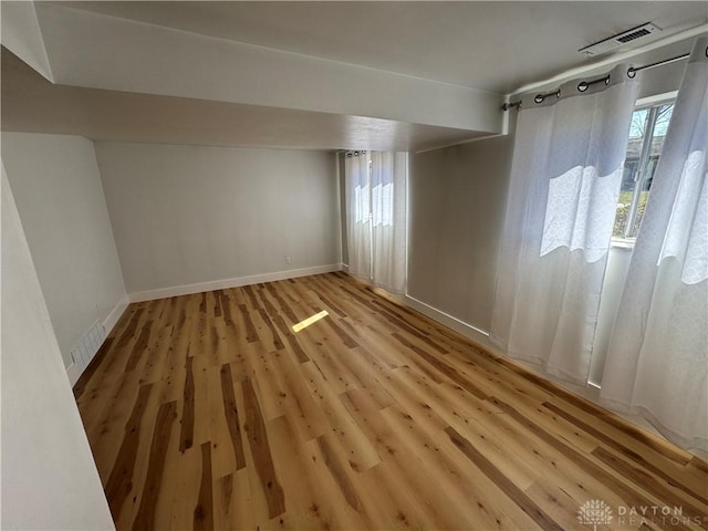 interior space featuring light wood-style floors, baseboards, and visible vents