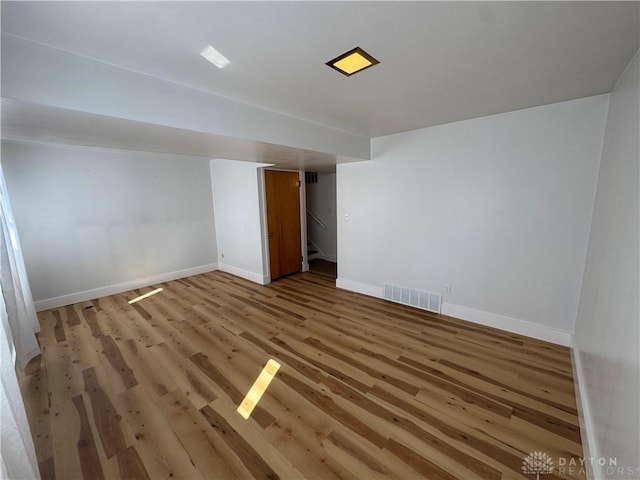 spare room featuring light wood-type flooring, baseboards, and visible vents