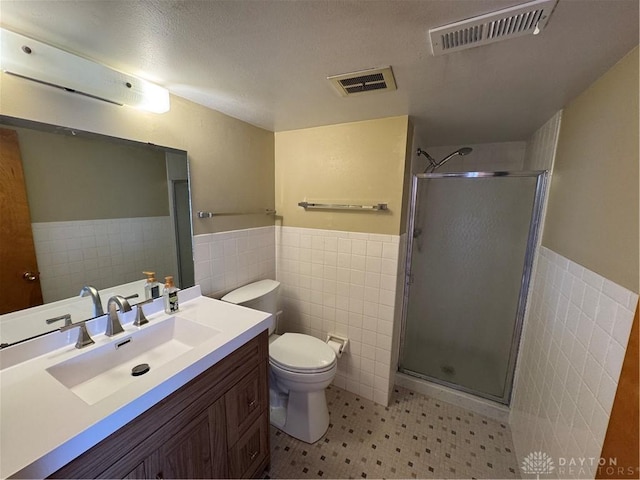 full bath featuring a stall shower, visible vents, and tile walls