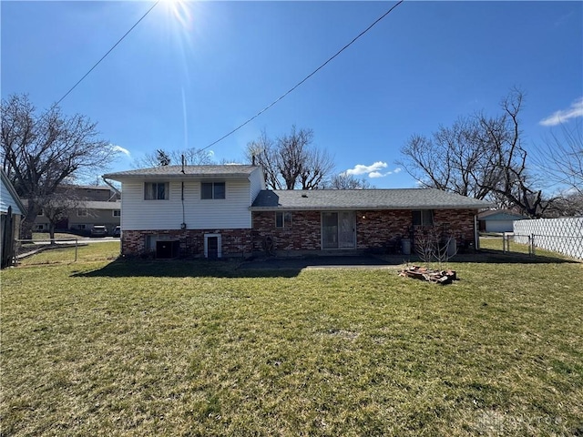 rear view of property with central air condition unit, fence, a lawn, and brick siding