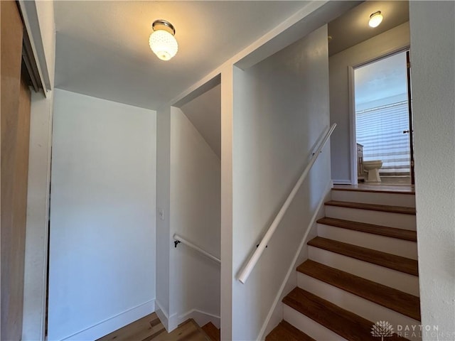 stairway featuring baseboards and wood finished floors