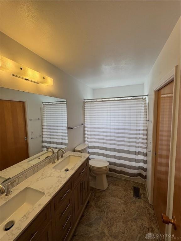 bathroom with toilet, visible vents, and a sink