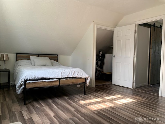 147 Mccraw Dr, Englewood, OH 45322 - bedroom with wood finished floors, vaulted ceiling, and a barn door
