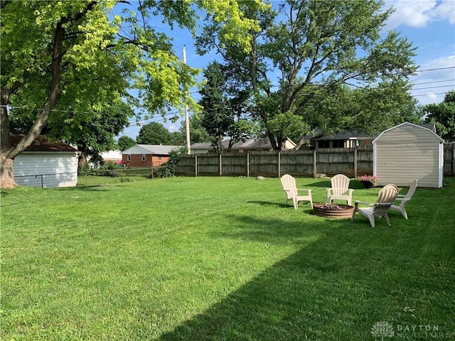147 Mccraw Dr, Englewood, OH 45322 - fenced backyard featuring a storage unit and a fire pit