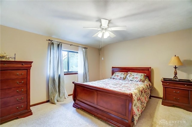 bedroom featuring light colored carpet, ceiling fan, and baseboards