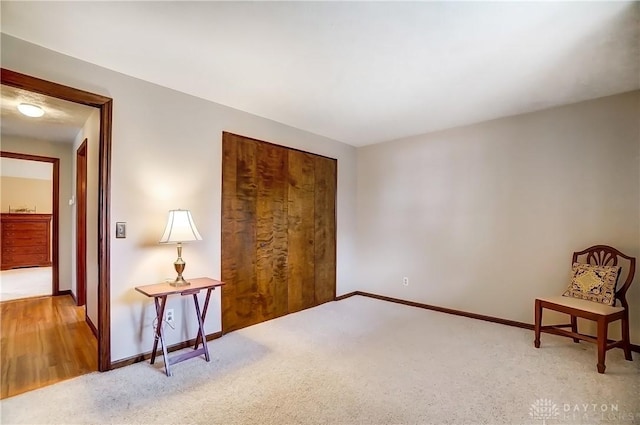 sitting room featuring carpet floors and baseboards