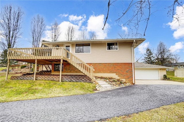 view of front of property featuring stairs, brick siding, a front yard, and a wooden deck