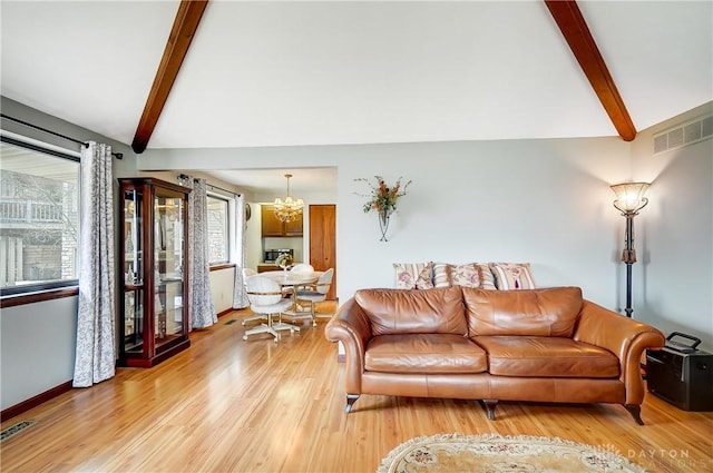 living room with a chandelier, visible vents, vaulted ceiling with beams, and light wood finished floors