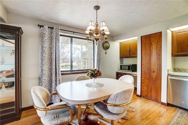 dining space featuring light wood-style floors, baseboards, and a notable chandelier