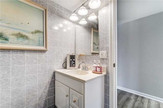 bathroom with tile walls, vanity, and wood finished floors