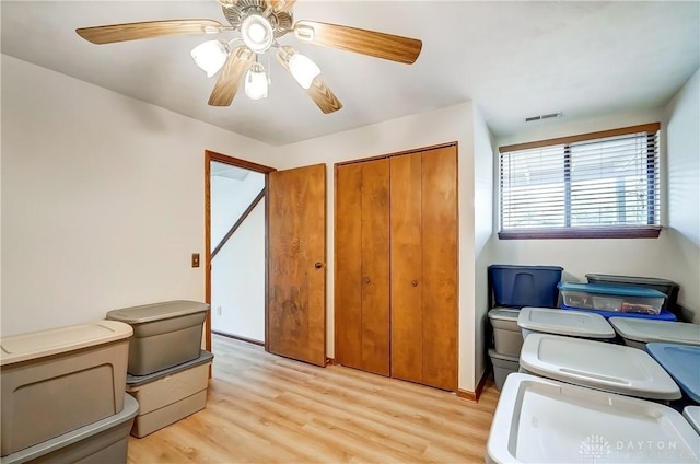 home office with ceiling fan, washer / dryer, light wood-type flooring, and visible vents