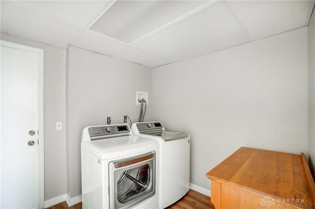 clothes washing area with laundry area, washing machine and clothes dryer, and baseboards