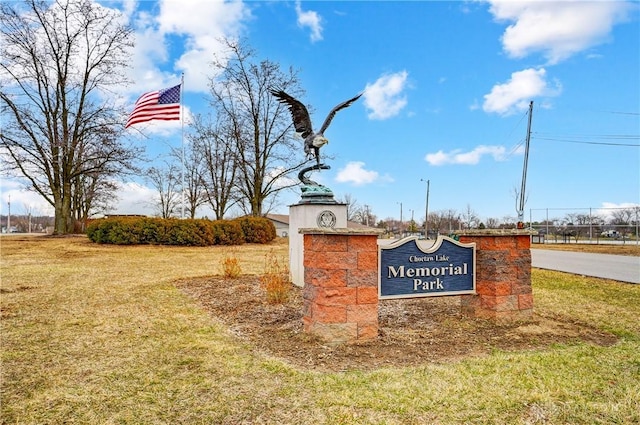 community / neighborhood sign featuring a yard