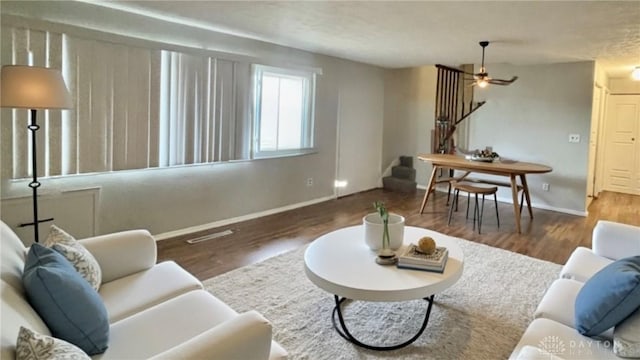 living room featuring stairs, wood finished floors, and baseboards