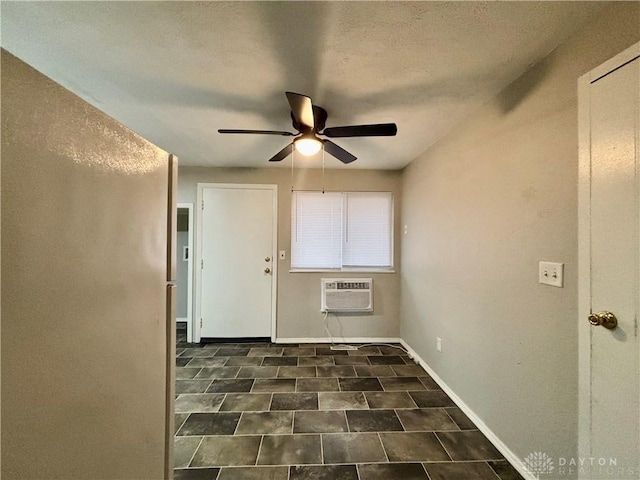 empty room featuring baseboards, a wall mounted air conditioner, and ceiling fan