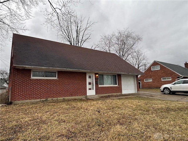 view of front facade featuring concrete driveway, a garage, brick siding, and a front yard