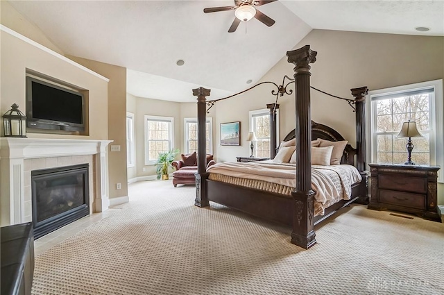 bedroom with lofted ceiling, carpet, a fireplace, and baseboards