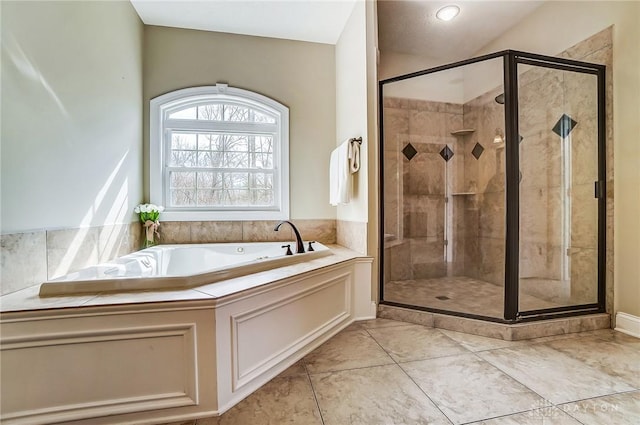 bathroom featuring a garden tub, a shower stall, and tile patterned floors