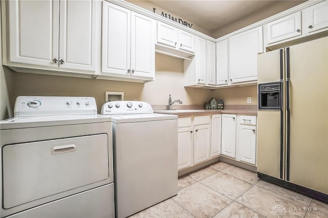 laundry area with cabinet space, washing machine and dryer, light tile patterned floors, and a sink