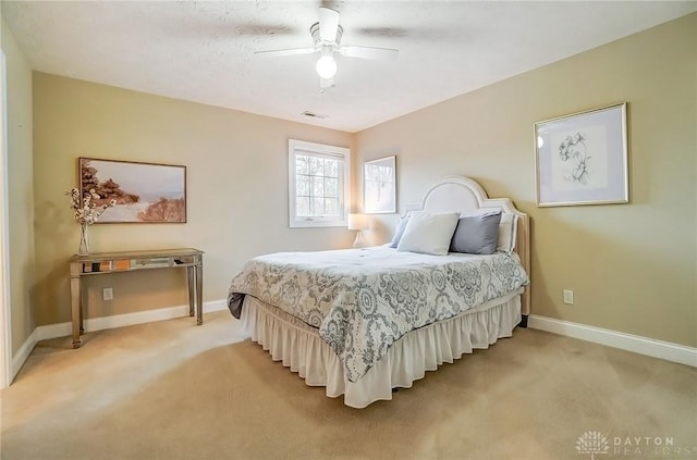 carpeted bedroom featuring a ceiling fan, visible vents, and baseboards