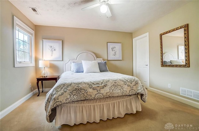 bedroom with light carpet, visible vents, and baseboards