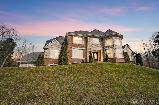 view of front facade featuring a front yard and brick siding