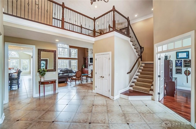 foyer featuring a towering ceiling, stairway, and baseboards