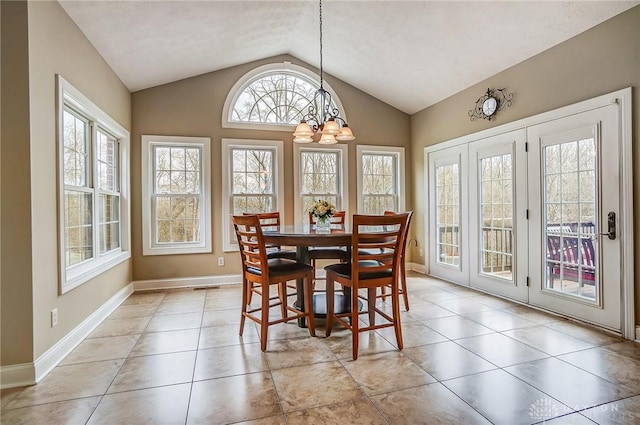 dining area with a wealth of natural light, light tile patterned flooring, vaulted ceiling, and an inviting chandelier