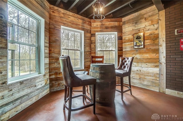 dining area featuring wood walls and concrete flooring