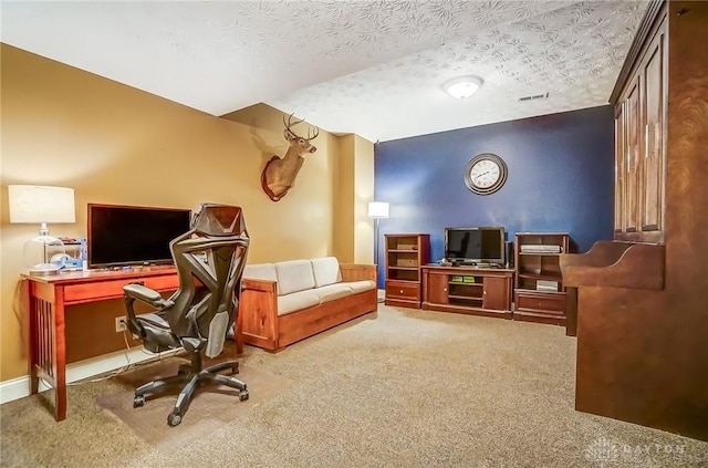 office featuring carpet floors, visible vents, and a textured ceiling