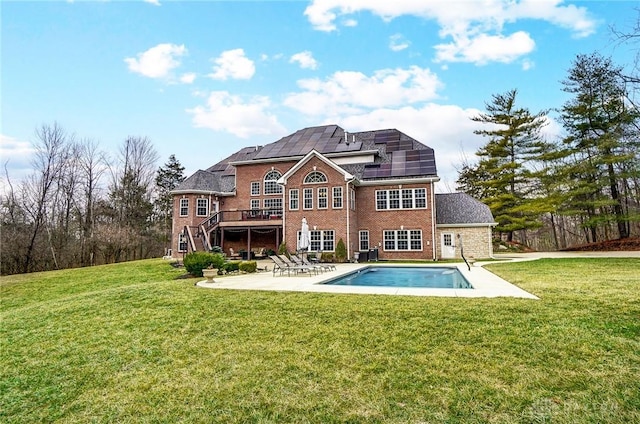 rear view of property featuring solar panels, a yard, stairway, and a patio area