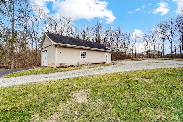 view of side of property with a garage and a lawn