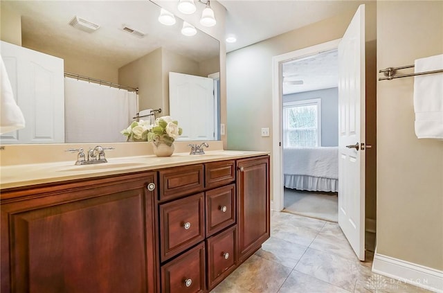 bathroom with double vanity, visible vents, and a sink