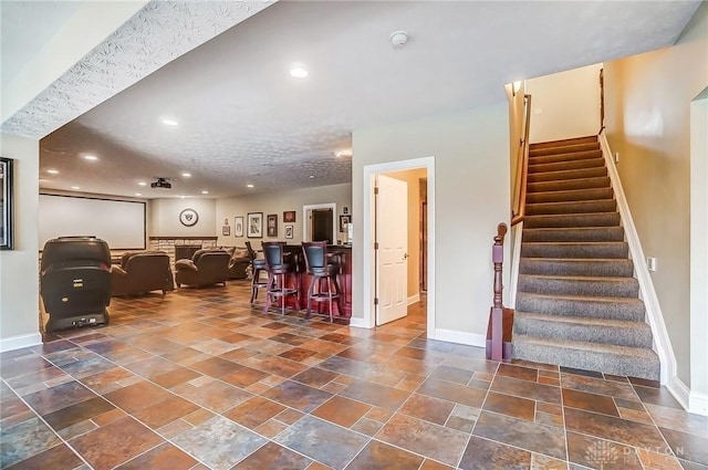 interior space with recessed lighting, baseboards, a dry bar, and stairs