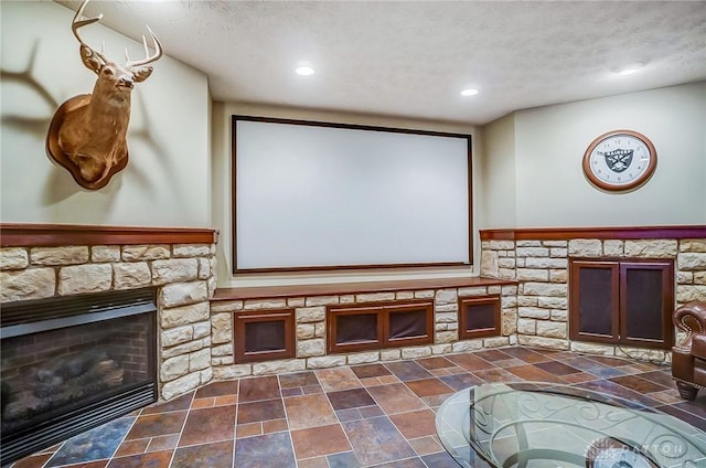 cinema room featuring a textured ceiling, a fireplace, and recessed lighting