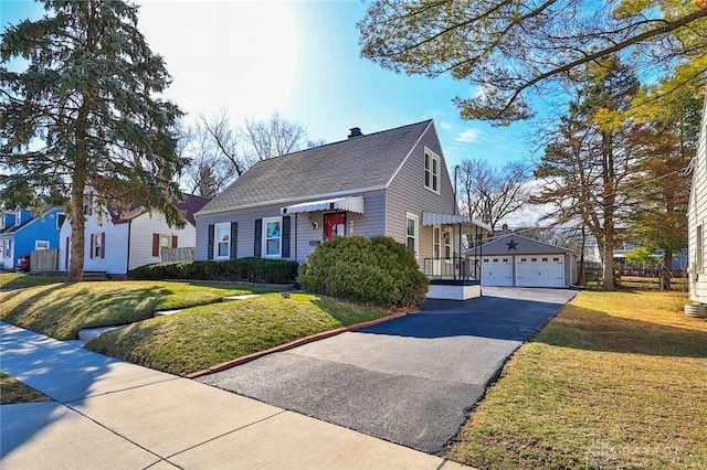 view of front of house with a garage, a front yard, and an outdoor structure