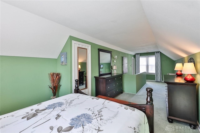 carpeted bedroom with lofted ceiling