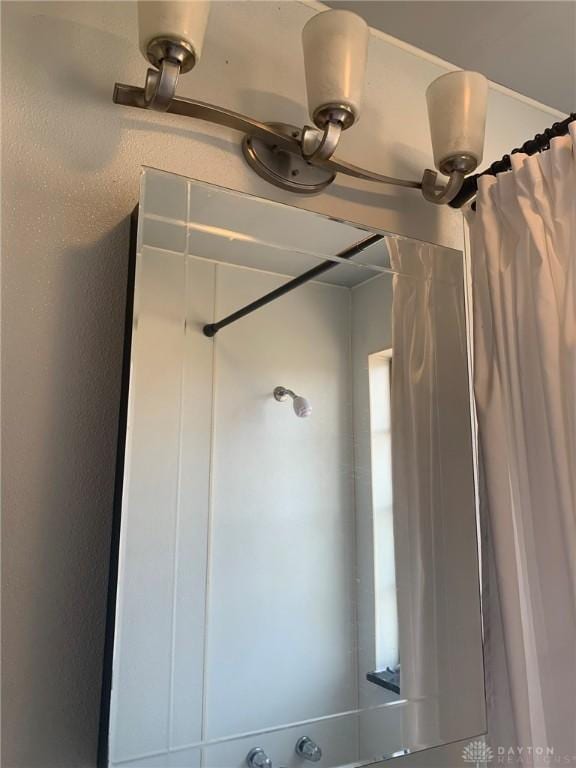 interior details featuring a shower with shower curtain