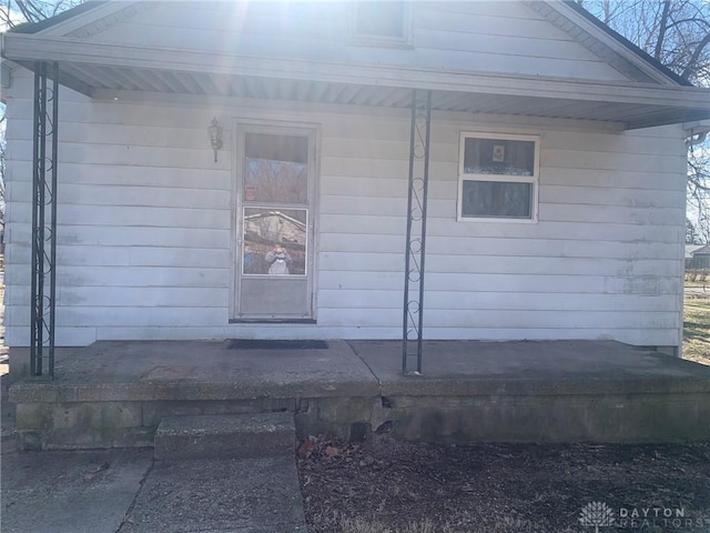 view of exterior entry featuring covered porch