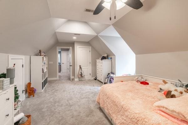 bedroom featuring vaulted ceiling, light colored carpet, visible vents, and ceiling fan