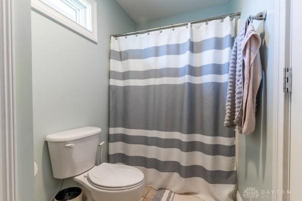 bathroom featuring a shower with shower curtain and toilet